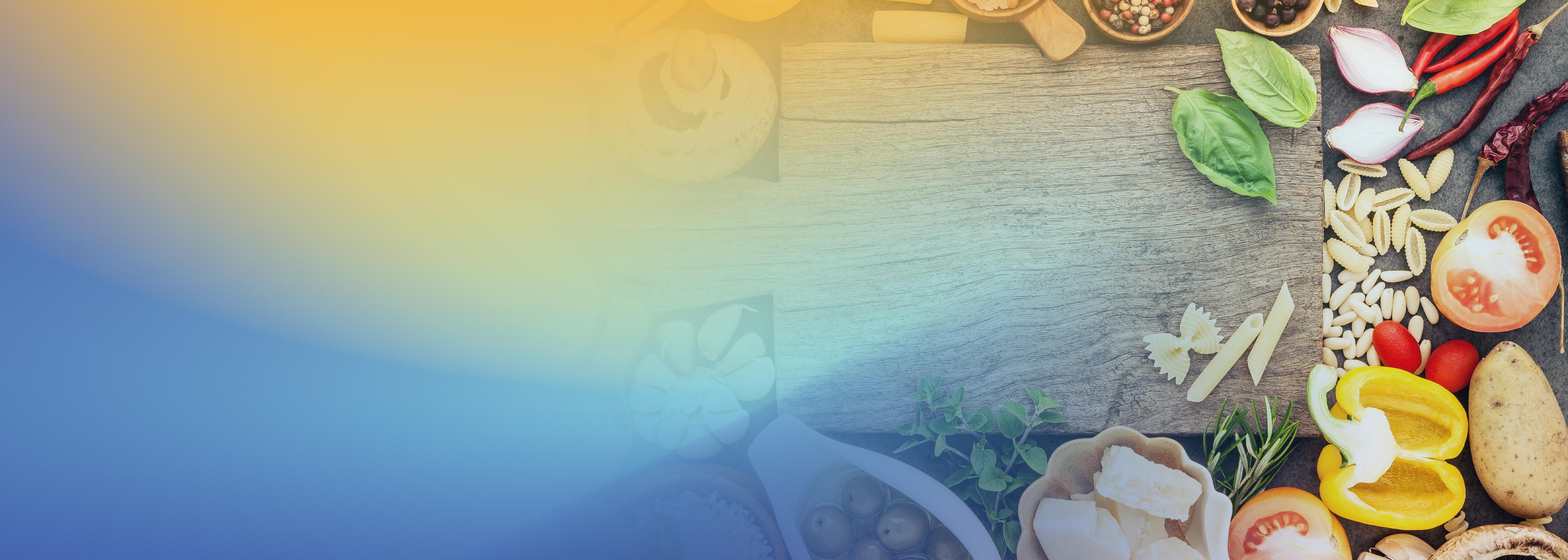 A variety of colorful Italian ingredients, such as pasta, tomatoes, peppers, beans, and herbs, arranged on the right side of a wooden table with a blue and yellow gradient background on the left.