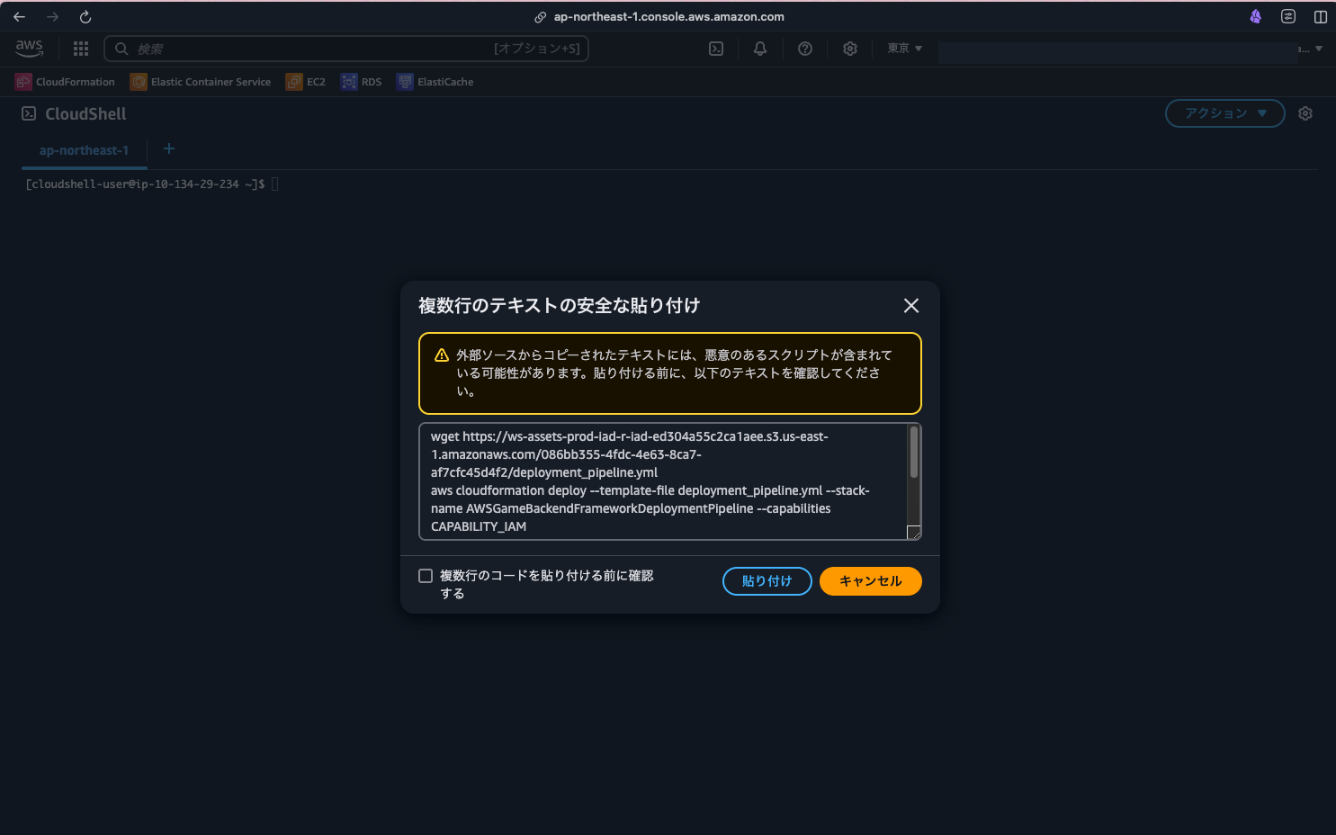Screenshot of the AWS CloudShell interface displaying a multiline text safety warning dialog in Japanese. The dialog cautions users about the potential risks of pasting text copied from external sources and presents a sample deployment command. The interface features AWS services and is presented in dark mode.