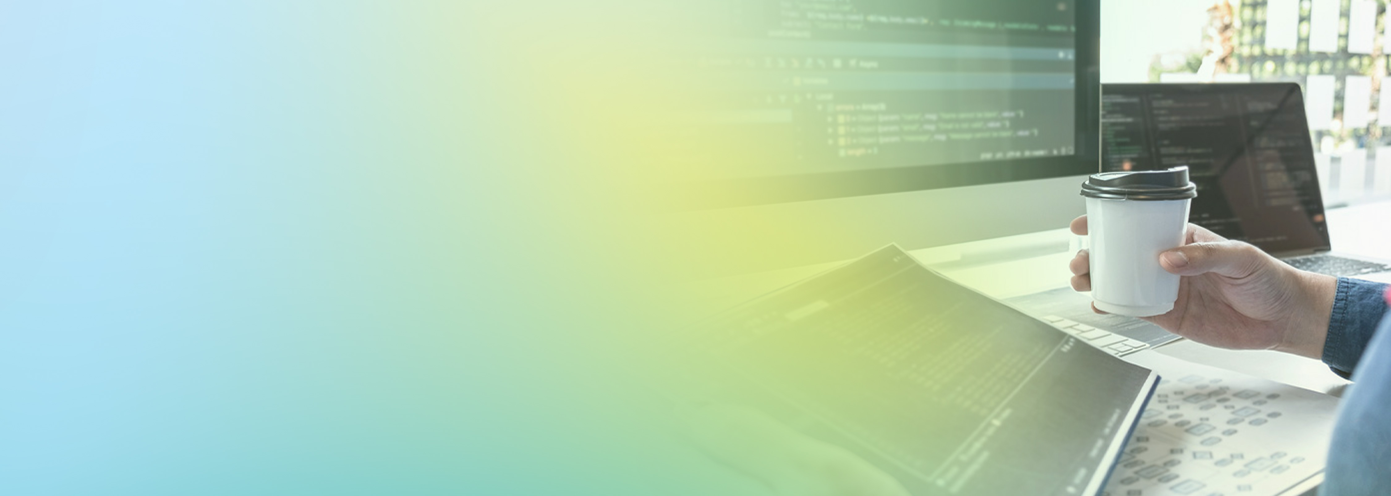 A person holding a paper coffee cup sits at a desk with a computer monitor and laptop displaying code, with documents and notes on the desk. The image features a blue and yellow gradient overlay.