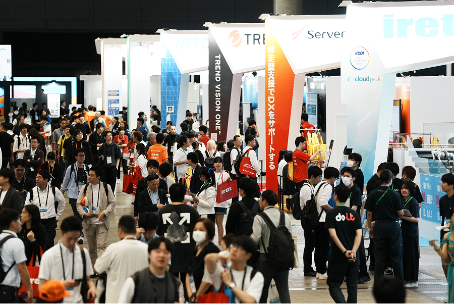 Large crowd attending the AWS Summit 2025 Japan Partner Expo, with multiple exhibition booths and people engaging in discussions and activities.