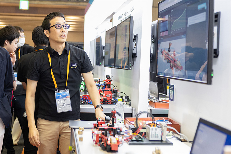 A tech exhibit showcasing robotics and data visualizations on screens, with equipment and monitors displayed on tables.