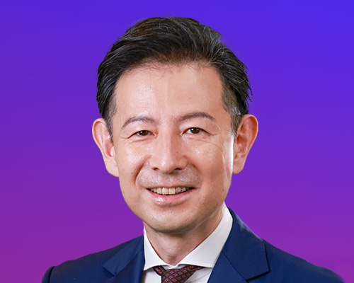 Portrait of a smiling business professional in a suit and tie, set against a blue-purple gradient background.