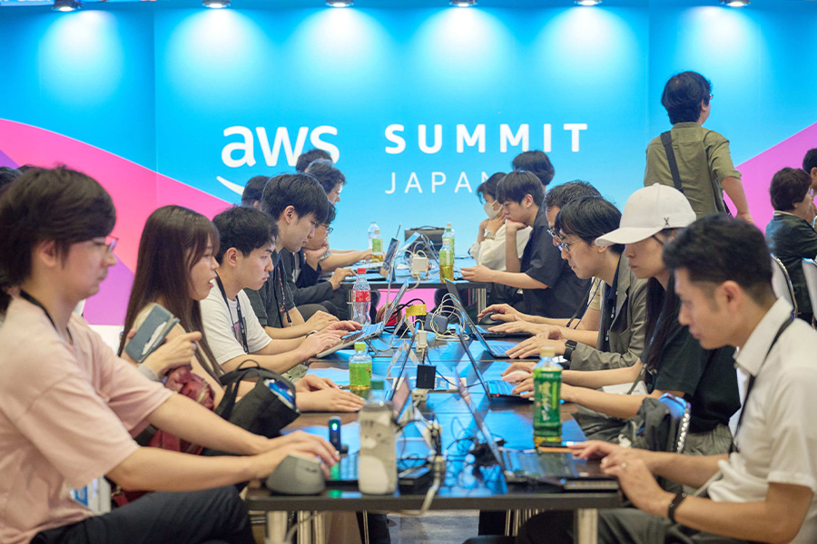 Participants at the AWS Summit Japan Expo hands-on lab are seated at tables working on laptops, engaging in practical learning activities in a collaborative event environment.