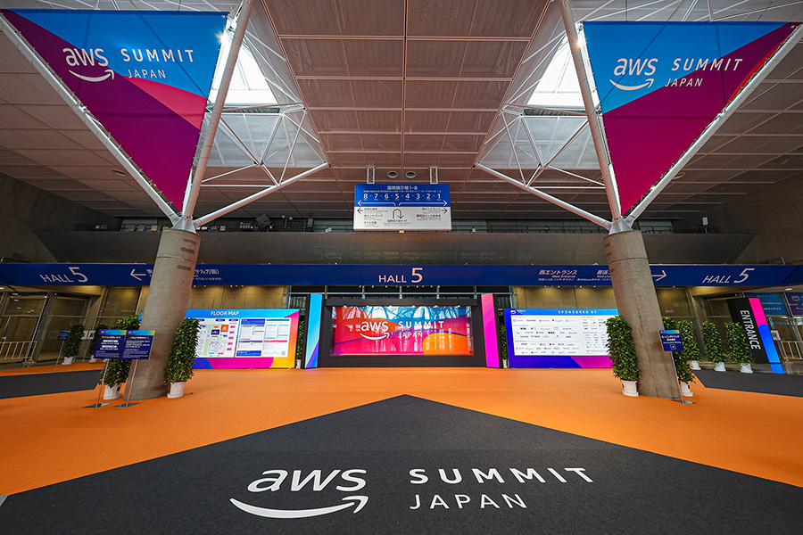 The entrance to Hall 5 at AWS Summit Japan, featuring bright signage, event banners, and digital displays for the 2025 event.
