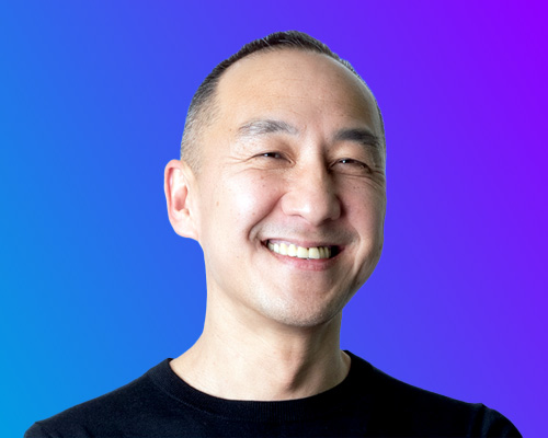 Portrait of smiling man at AWS Summit Japan with gradient blue and purple background