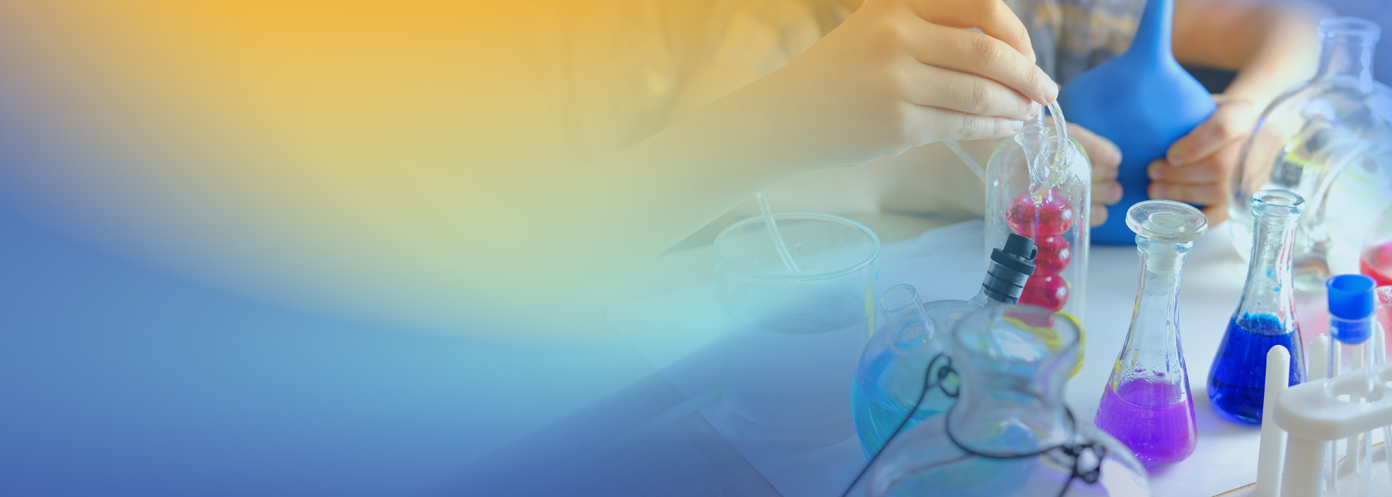 A child engaging in a hands-on science experiment with various colorful chemical flasks and laboratory glassware on a table.