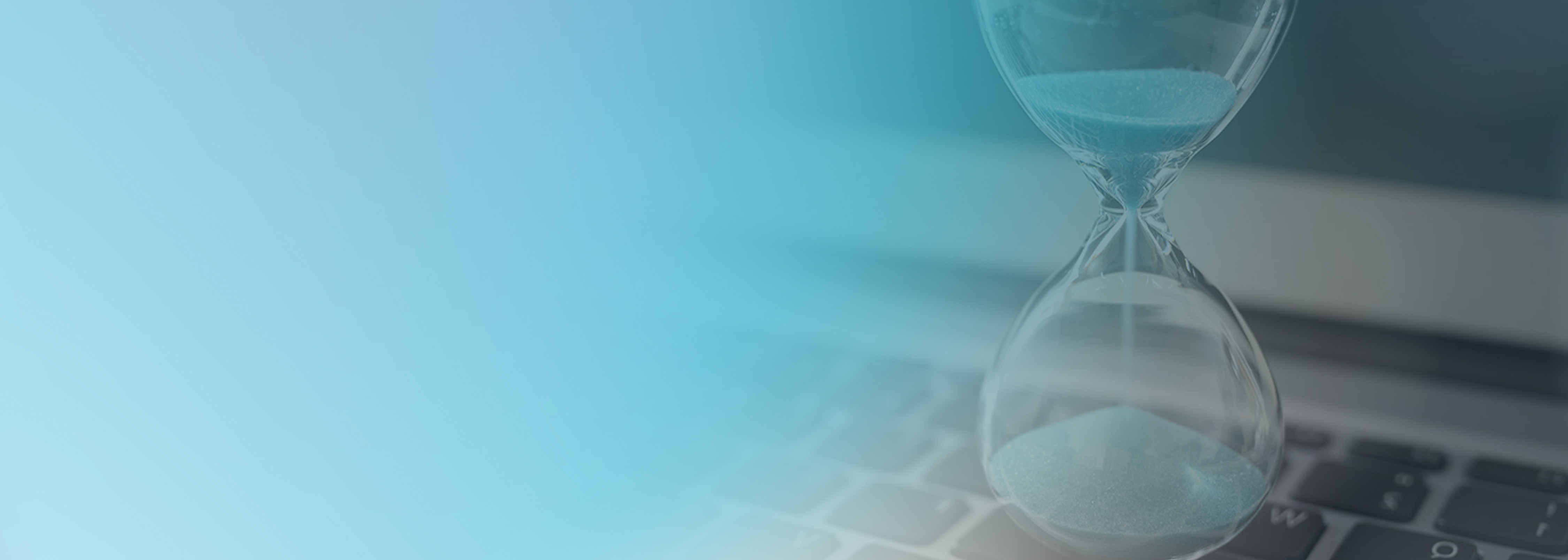 An image showing an hourglass on a laptop keyboard, symbolizing time management and scheduling for AWS Step Functions serverless workflows.