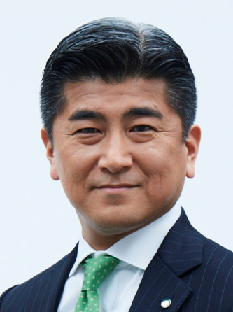 A person wearing a dark pinstripe suit, white shirt, and green polka-dot tie.