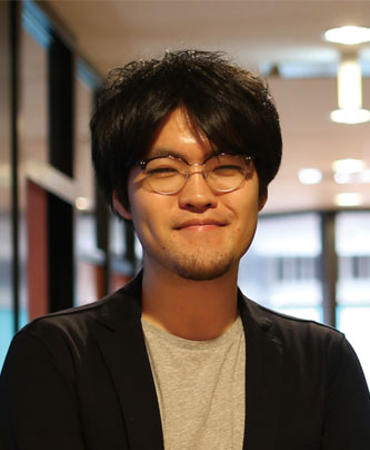 Portrait of a RareJob Technologies speaker, Haneda Kentaro, in a casual indoor setting with glasses and a slight smile.