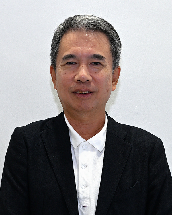 Portrait of an individual in a black blazer and white shirt, standing in front of a plain white background.