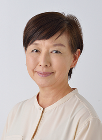Professional portrait of a middle-aged woman with short dark hair, wearing a light-colored buttoned shirt, against a plain light background.
