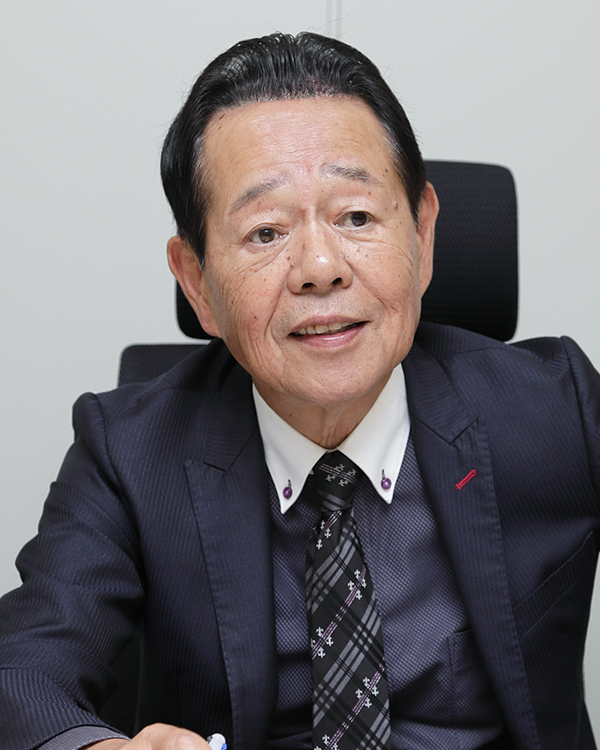 Portrait of a business professional in a suit, seated and speaking, used for a MK System case study.