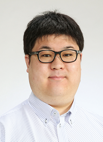 Portrait photo of a person wearing glasses and a white collared shirt, facing forward with a neutral background.