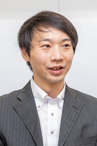 A portrait of a man in a business suit, facing forward, with a white background.