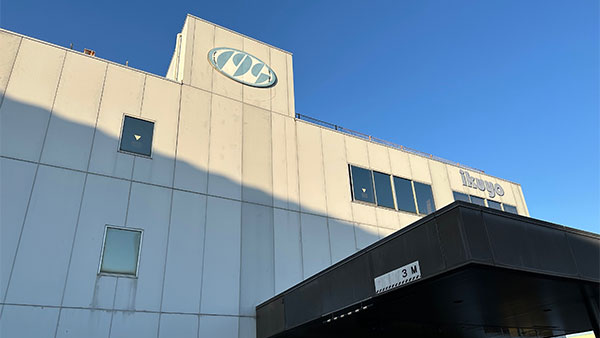 The exterior view of the Ikuyo corporate building under a clear blue sky.
