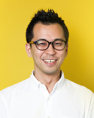 A person wearing a white button-up shirt stands against a bright yellow background.