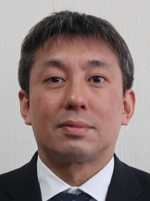 Portrait photo of a male speaker associated with the Iwate System Development case study, dressed in a suit.