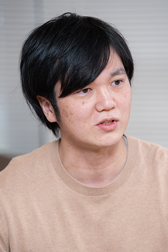 Portrait of a person featured in the Nulab case study, wearing a beige sweater and looking slightly to the side.