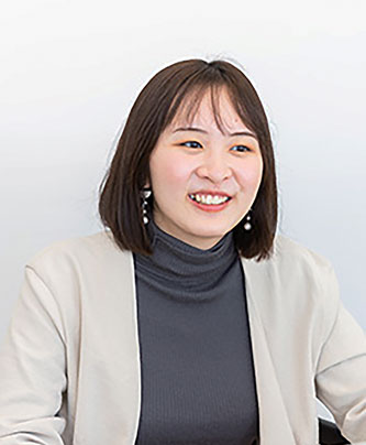 Portrait of a woman, Koinuma Kaho, speaker for the Base Food case study, sitting and smiling in a professional setting.