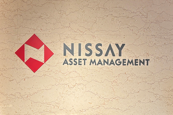 Nissay Asset Management logo with a red geometric design on a beige marble background.