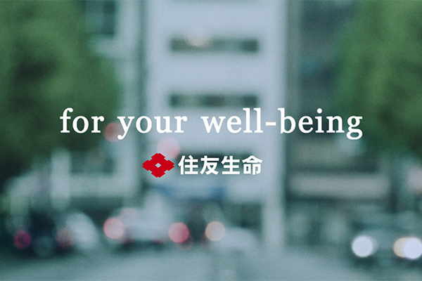 Alt-text: Blurred city street background with the text "for your well-being" and Japanese characters alongside a red logo.