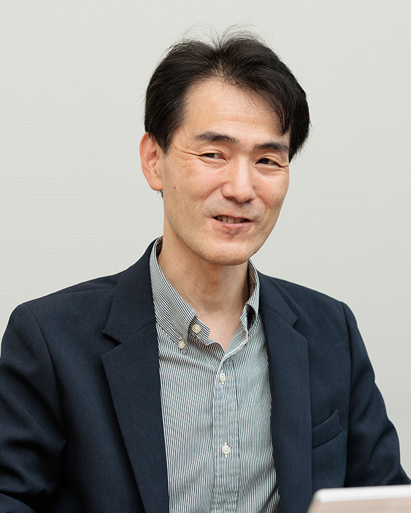 Portrait of a business professional in a suit, photographed in an interview or meeting setting for Sumitomo Life's case study.
