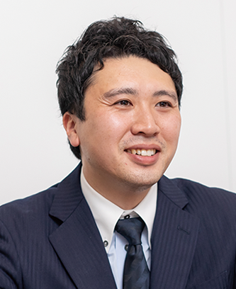 A man in a dark suit and tie, seated and smiling, suitable for a professional or case study context.