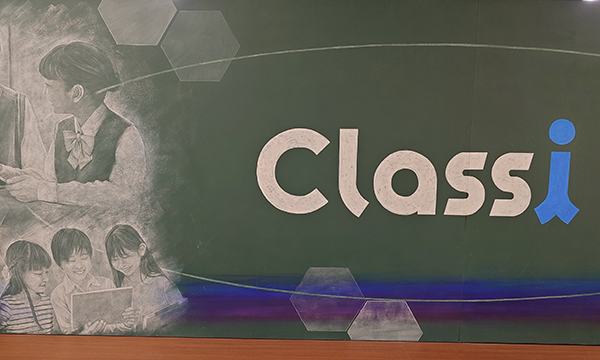 A mural featuring the Classi logo on a chalkboard, with chalk drawings of students using a tablet and a teacher in the background.