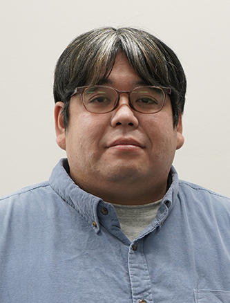 Portrait of a Geotechnologies employee wearing glasses and a blue button-up shirt, facing forward against a plain background.
