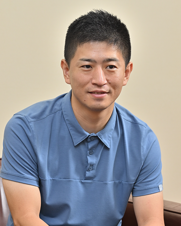 A professional portrait of a man in a blue polo shirt, used for the Takihyo case study on the AWS Japan website.