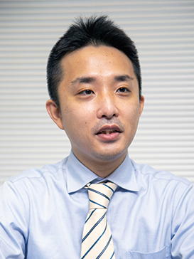 Portrait of Mr. Kasai from Ecostyle, featured in a solution case study, wearing a light blue shirt and striped tie.