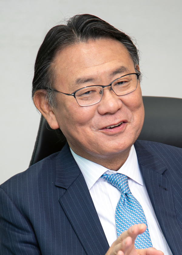 Portrait of a TV Tokyo executive in a business suit, seated and smiling, suitable for professional or corporate case study use.