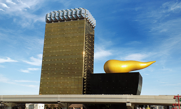Asahi Beer Hall in Tokyo, featuring a tall golden building and the iconic golden flame sculpture on a black base.