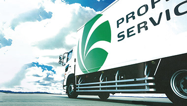 White truck with "Property Services" branding and a green logo, parked under a bright blue sky with scattered clouds.