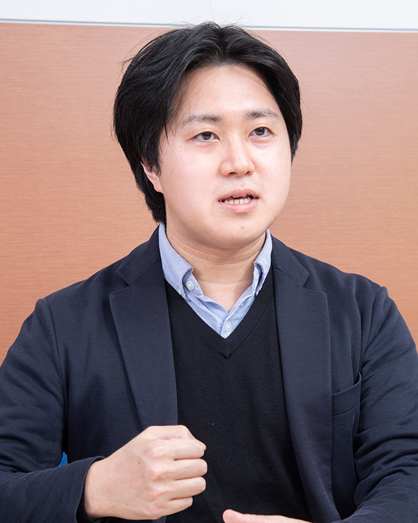 Business portrait of a person in a suit, used for the KDDI case study interview in Japan.