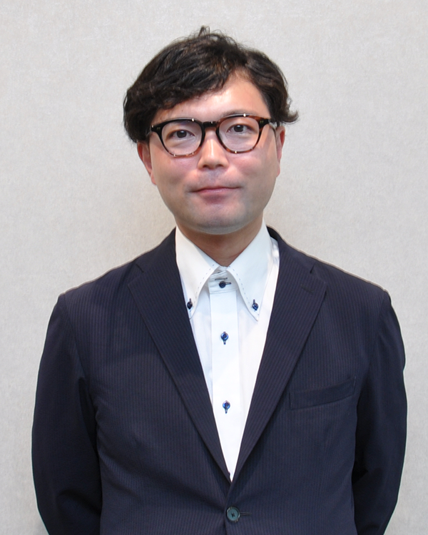 Portrait of a speaker in a suit and glasses against a plain background, used for the MUFG case study.