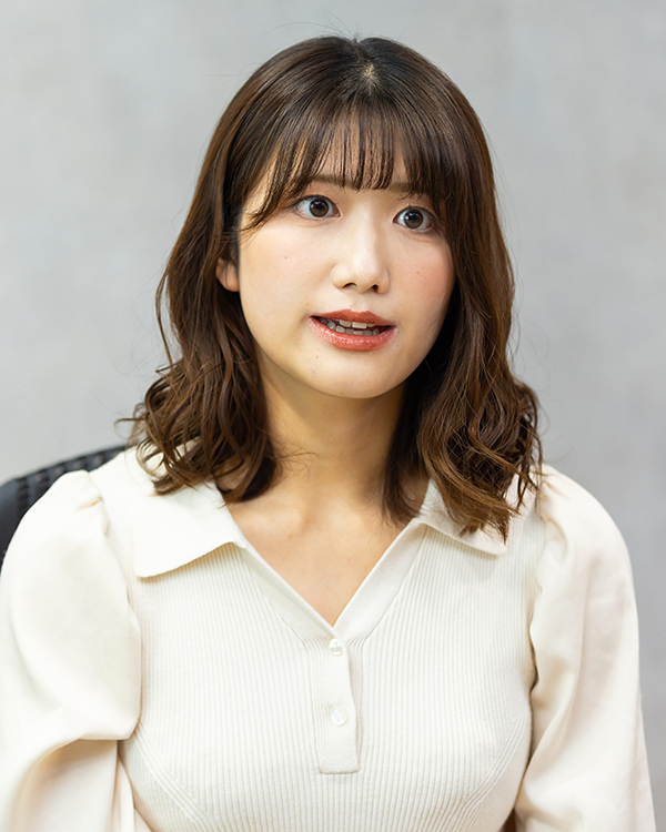 A portrait of a woman with shoulder-length brown hair, wearing a light-colored blouse, taken for the Asahi Shimbun case study profile.