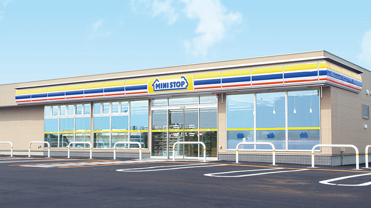 Exterior view of a Ministop convenience store in Japan with clear branding, parking lot, and modern storefront design.