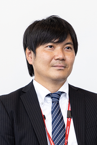 Portrait of a business professional in formal attire with a Yanmar-branded lanyard, suitable for use in business or corporate case study contexts.