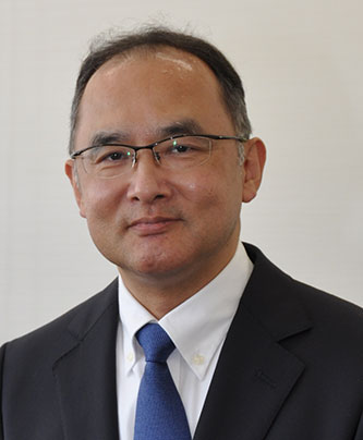 Portrait of Sakaguchi Joji, featured in the AWS Nichirei case study, wearing a suit and blue tie, facing forward.