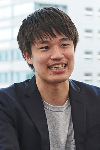A portrait of a person interviewed for RPA Technologies, wearing a dark blazer and gray shirt, with a cityscape blurred in the background.