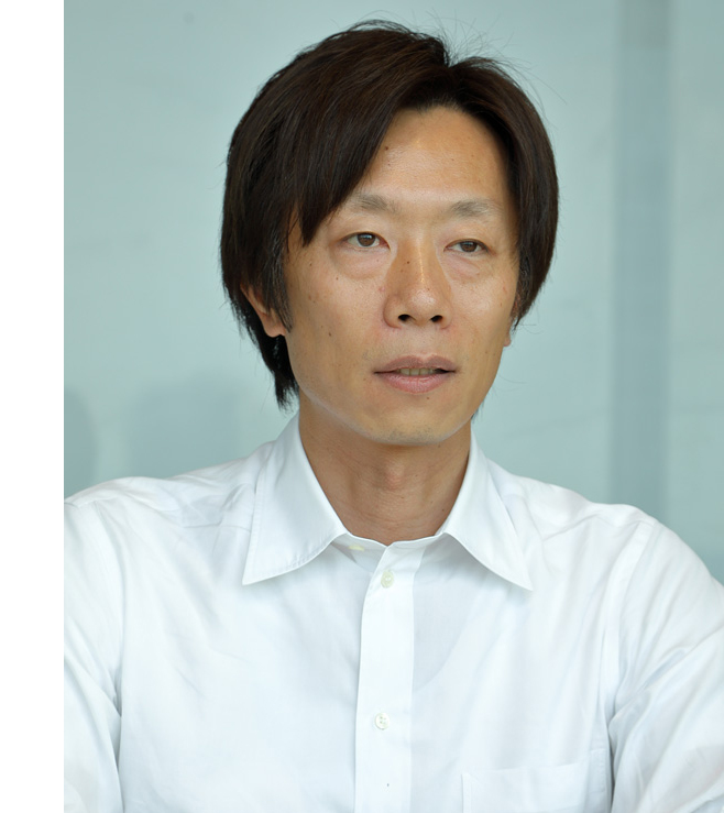 Portrait of a businessman wearing a white shirt, looking ahead against a light background.