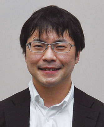 Portrait photo of Suzuki Haruhito, a speaker featured in the Fujifilm case study, wearing glasses, a suit, and a white shirt.
