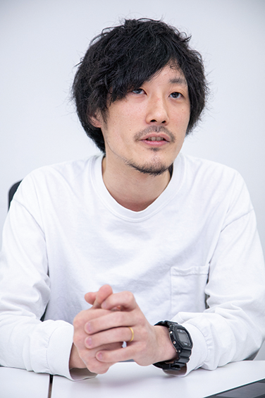 A portrait of a man in a white shirt during an interview, used for a ZOZO Technologies case study.