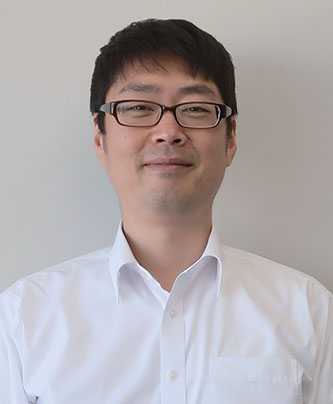 A person wearing a white collared shirt against a plain background.