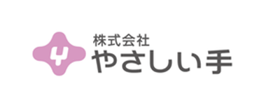 Logo for YASASHII-TE company featuring stylized Japanese text and a pink symbol.