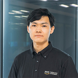 Professional portrait of an AWS Training and Certification team member wearing an AWS-branded shirt, in an office environment.