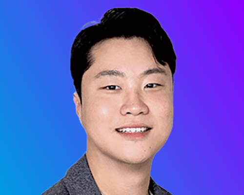 A person with short black hair wearing a gray collared shirt, set against a gradient blue-to-purple background.