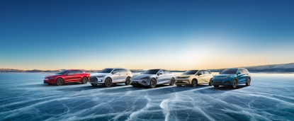 A lineup of BYD electric cars positioned on a frozen, icy landscape with a clear sky and sunset in the background.