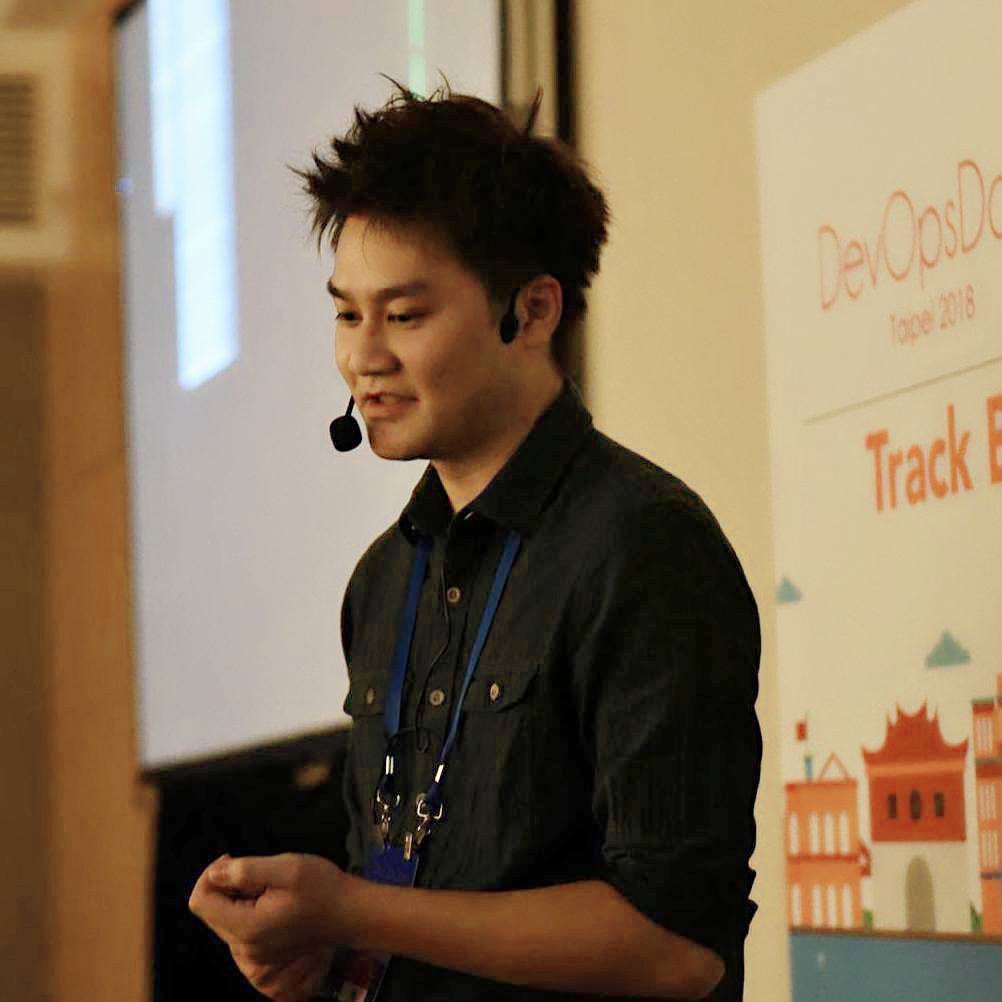A speaker presenting at DevOpsDays Taipei 2018, Track B session, standing at the podium with a headset microphone.